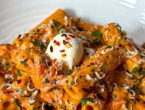 Delicious creamy garlic tomato pasta dish garnished with fresh herbs